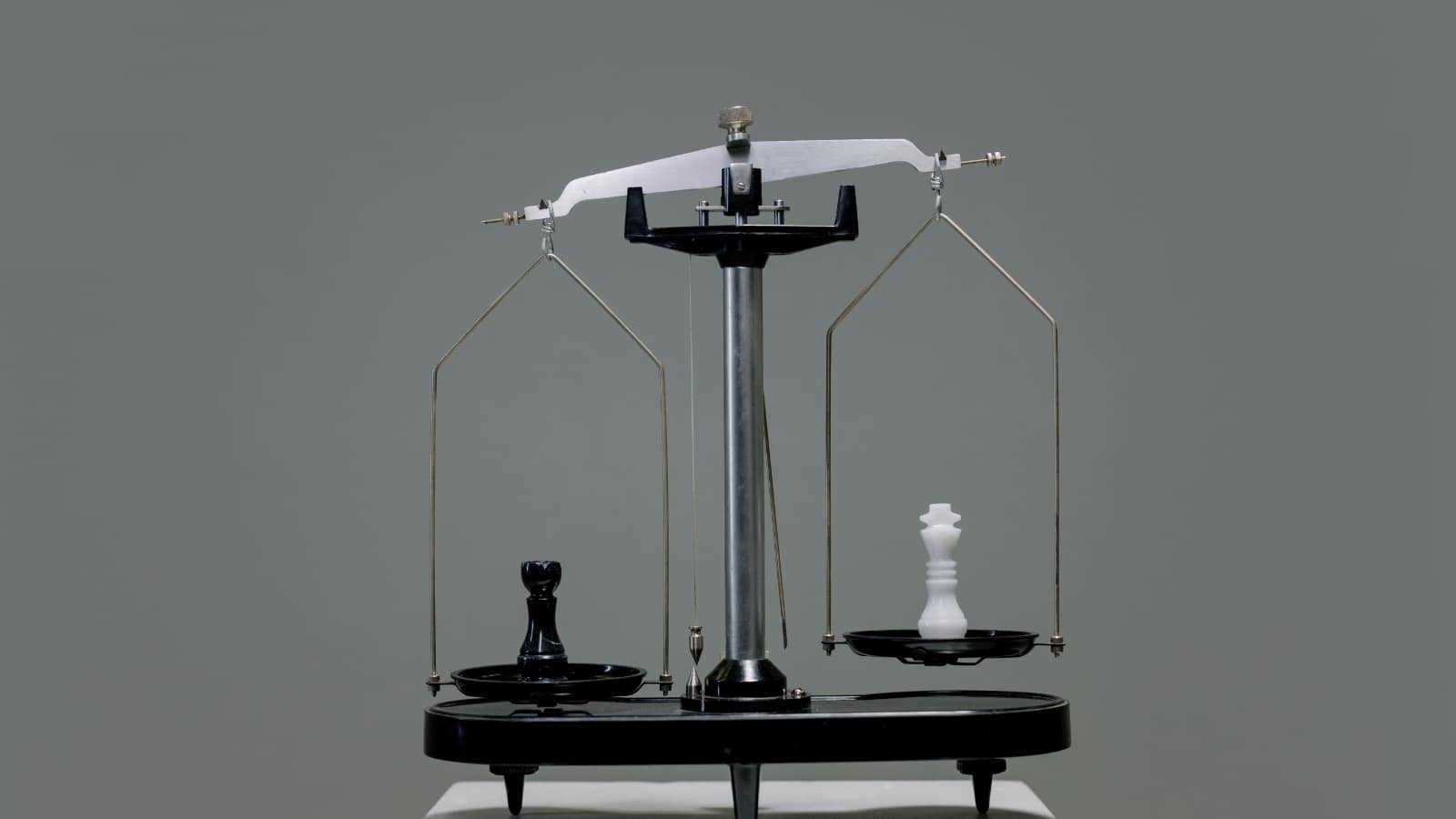 Figury szachowe ustawione na szalkach wagi, symbol porównania Bielik AI z ChatGPT i innymi narzędziami dla tłumaczy