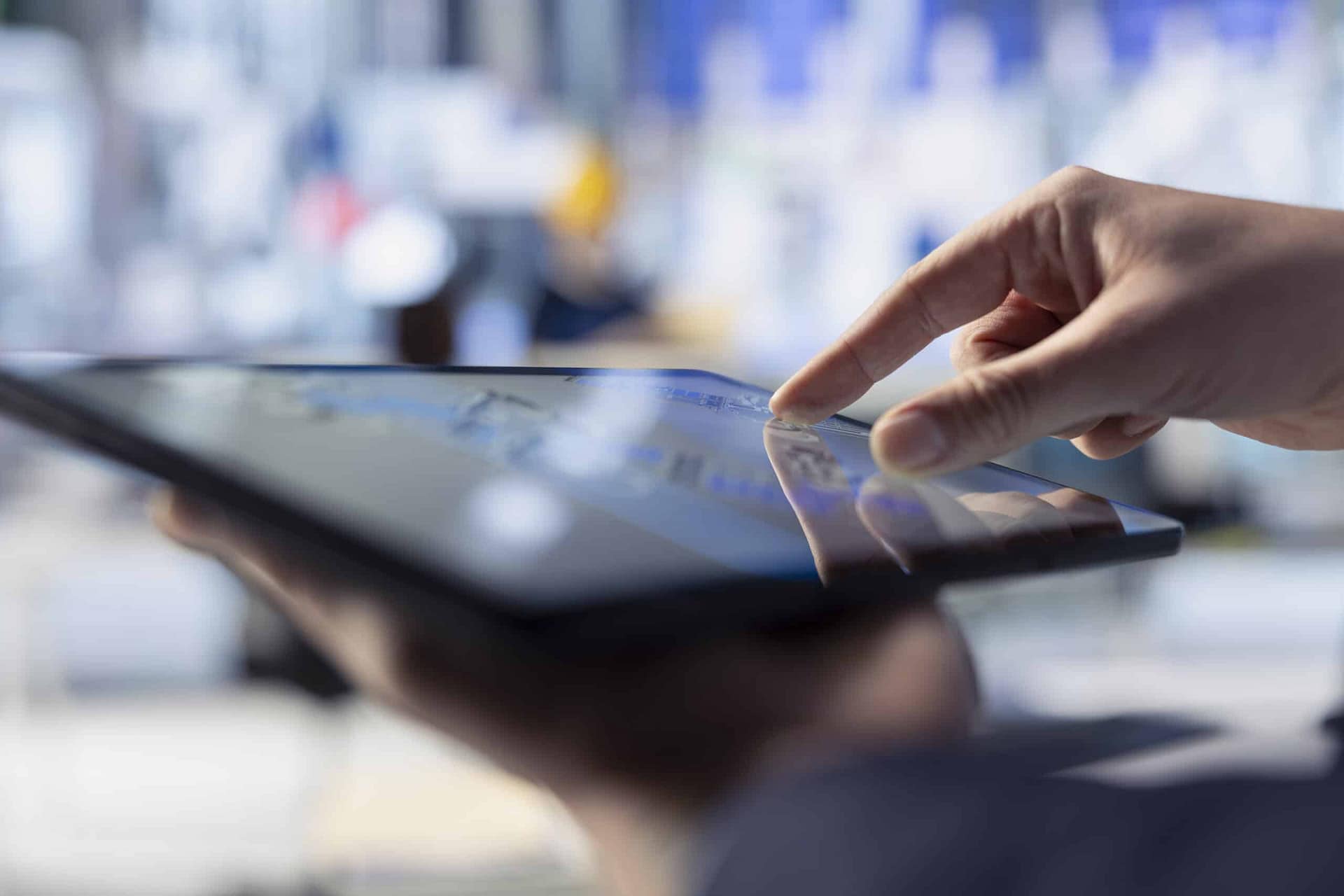 Hand touching a tablet screen symbolizing sales automation