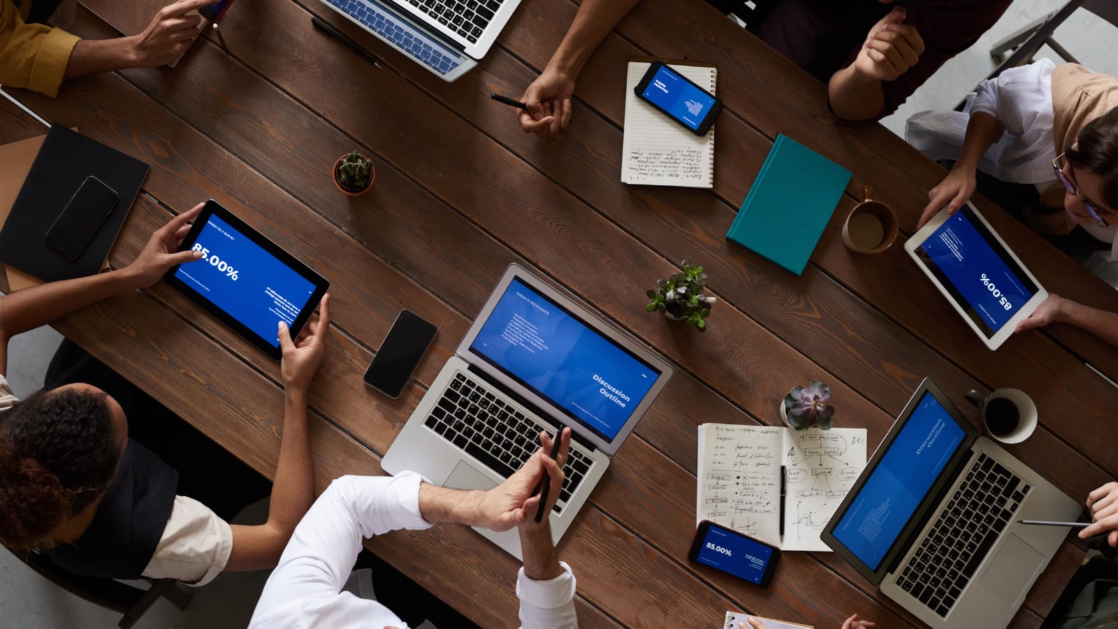 Ahrefs i AI – zespół ludzi przy stole pracujący nad strategią SEO na laptopach
