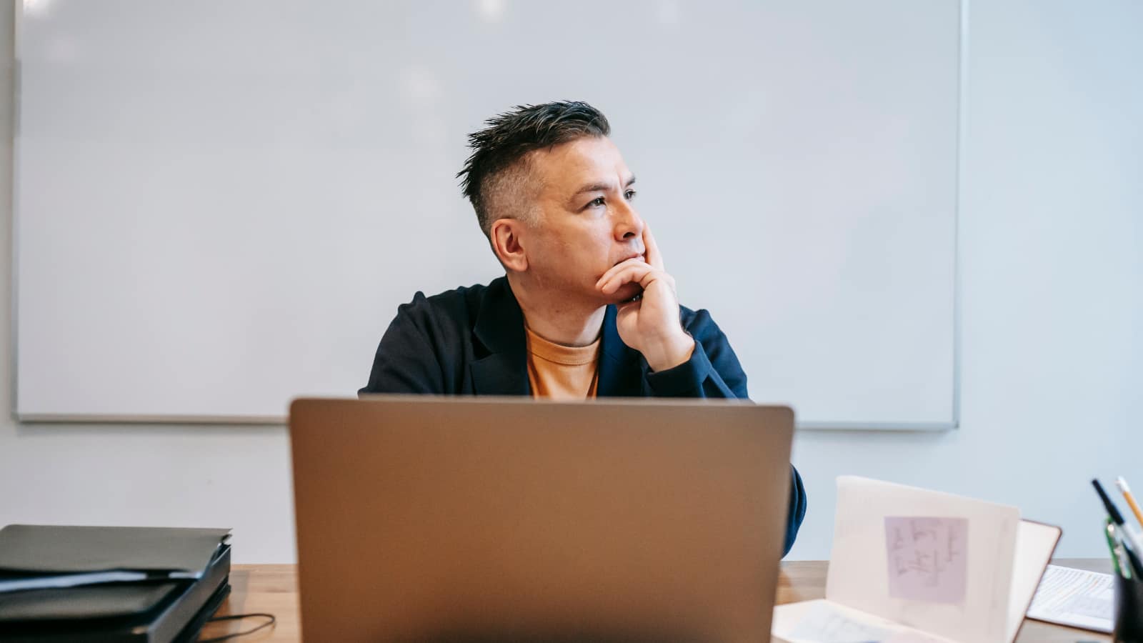AI w e-commerce – osoba myśląca przed laptopem, symbolizująca błędy przy wdrażaniu automatyzacji obsługi klienta