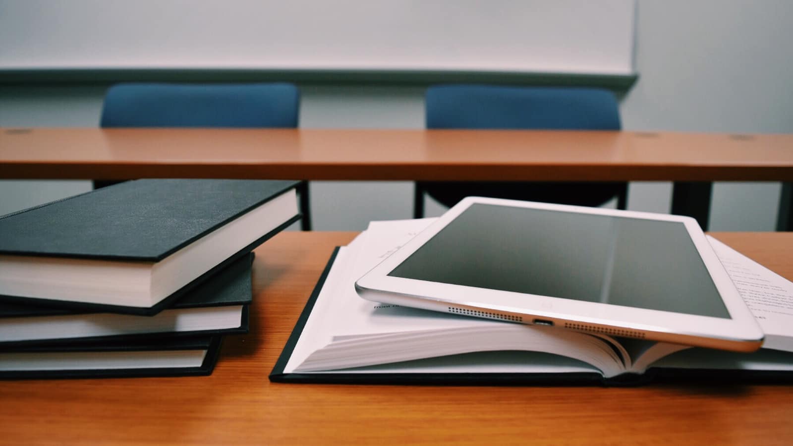 Ławka szkolna z książkami i tabletem, symbolizująca nowoczesną edukację wspieraną przez sztuczną inteligencję