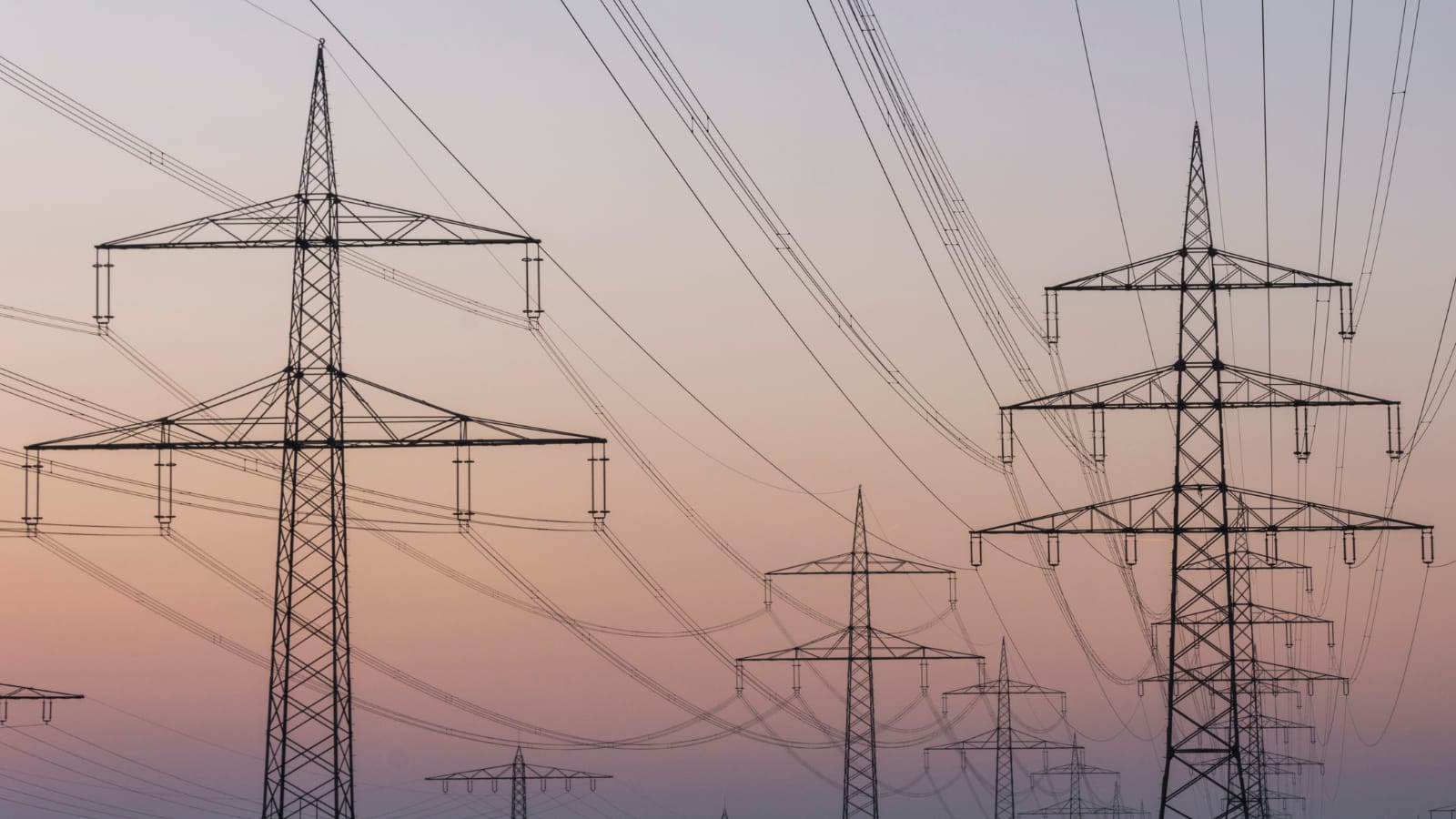 Linie wysokiego napięcia na tle nieba, symbolizujące zastosowanie sztucznej inteligencji w optymalizacji energetyki i ekologii