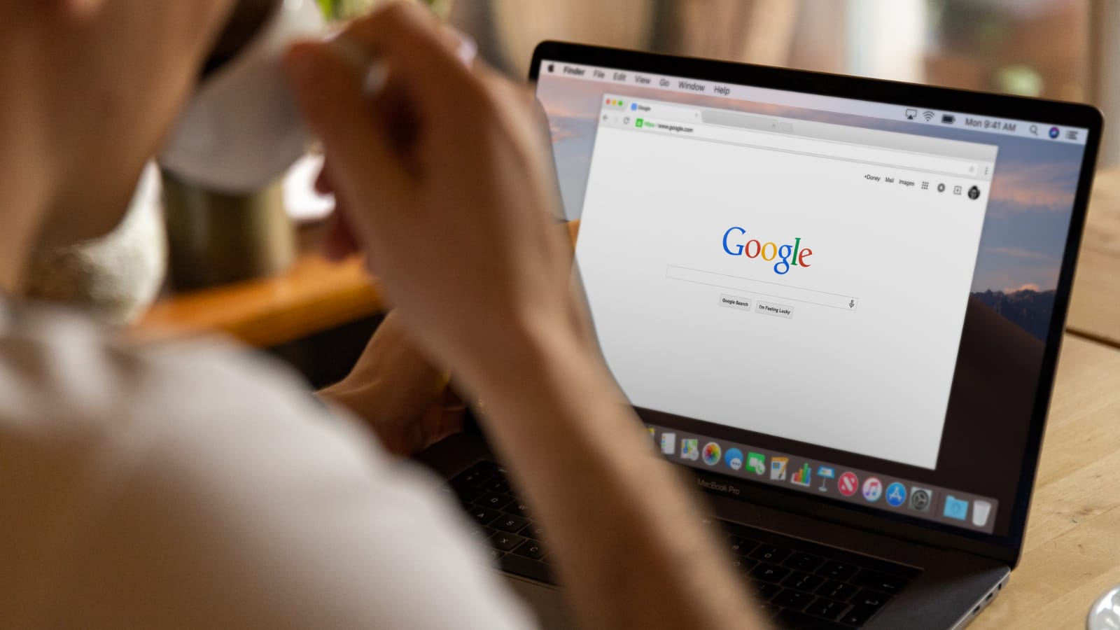Człowiek przed laptopem z kawą – korzysta z AI SEO content i przegląda wyniki w Google