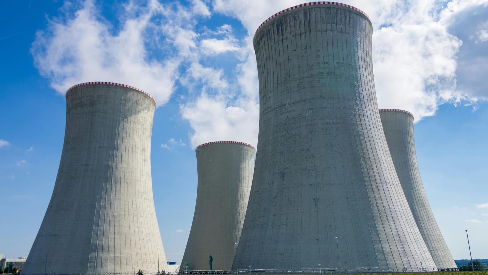 Kominy elektrowni cieplnej z widocznym dymem – przykład wyzwań ekologicznych w energetyce, gdzie sztuczna inteligencja w energetyce pomaga optymalizować emisje.