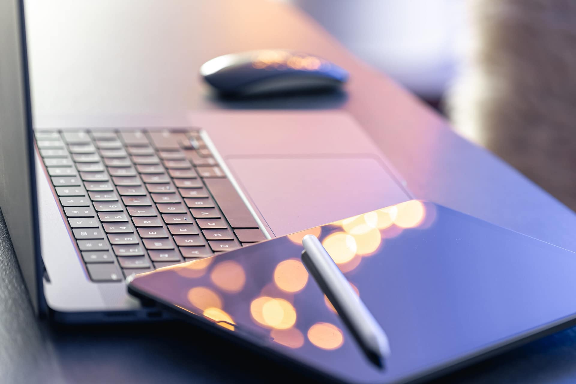 Modele zarabiania na podcastach AI – laptop, tablet i rysik jako narzędzia do planowania i strategii