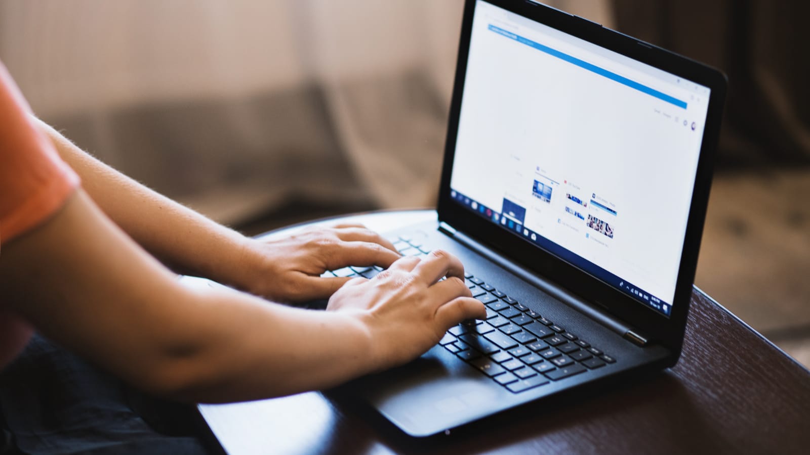 Dłonie na laptopie pracujące nad optymalizacją strony i SEO